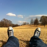 Picture of a man in a field, sitting back and relaxing.